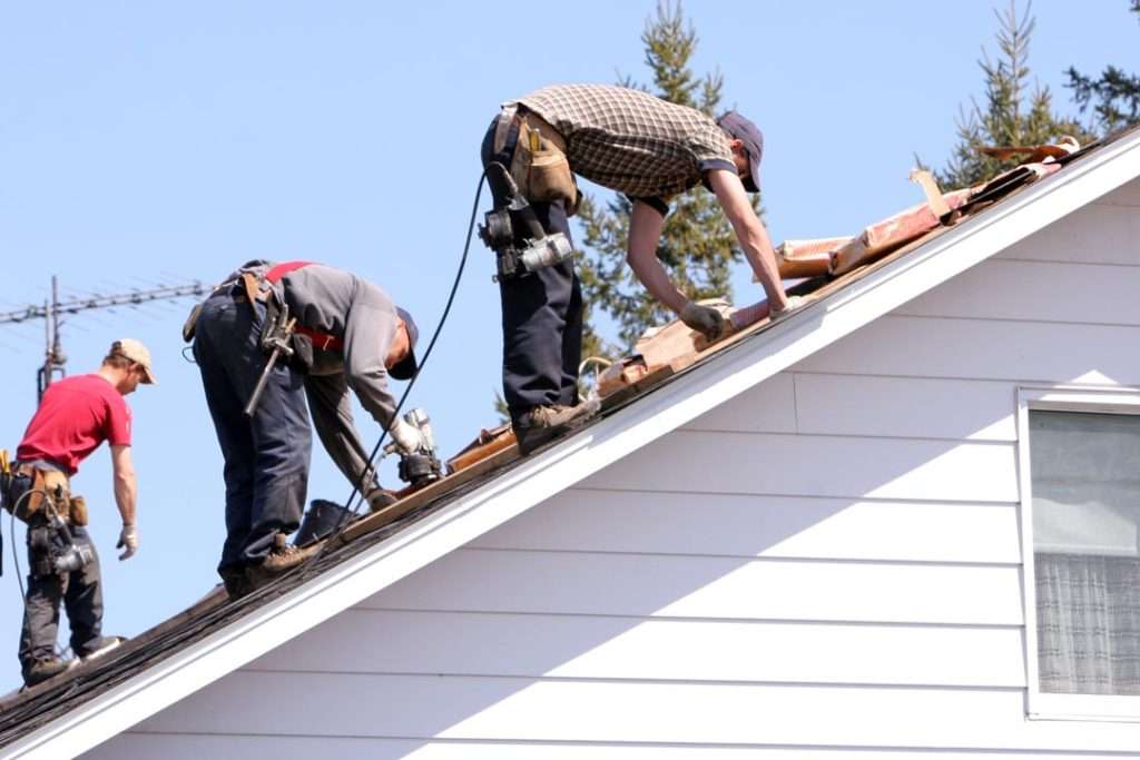 roofer repairing and replacing damaged shingles